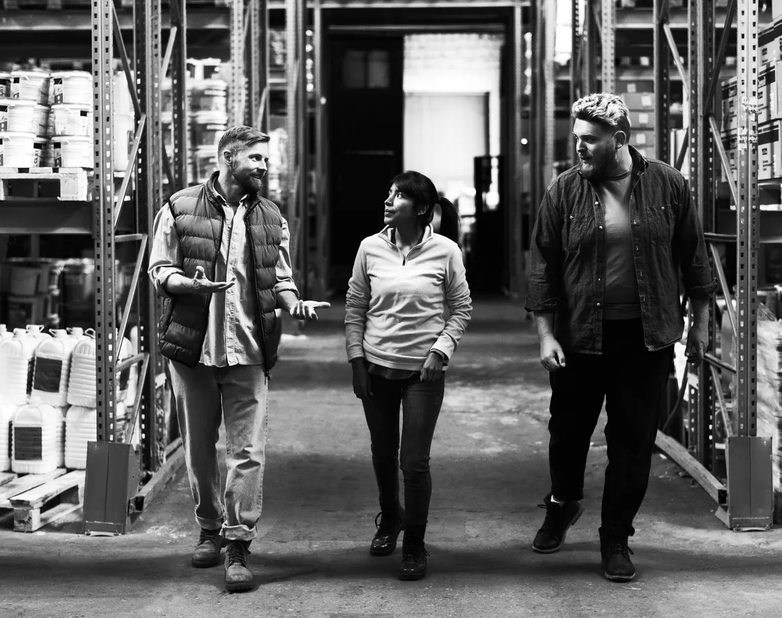 Three logistics team members walking through a warehouse